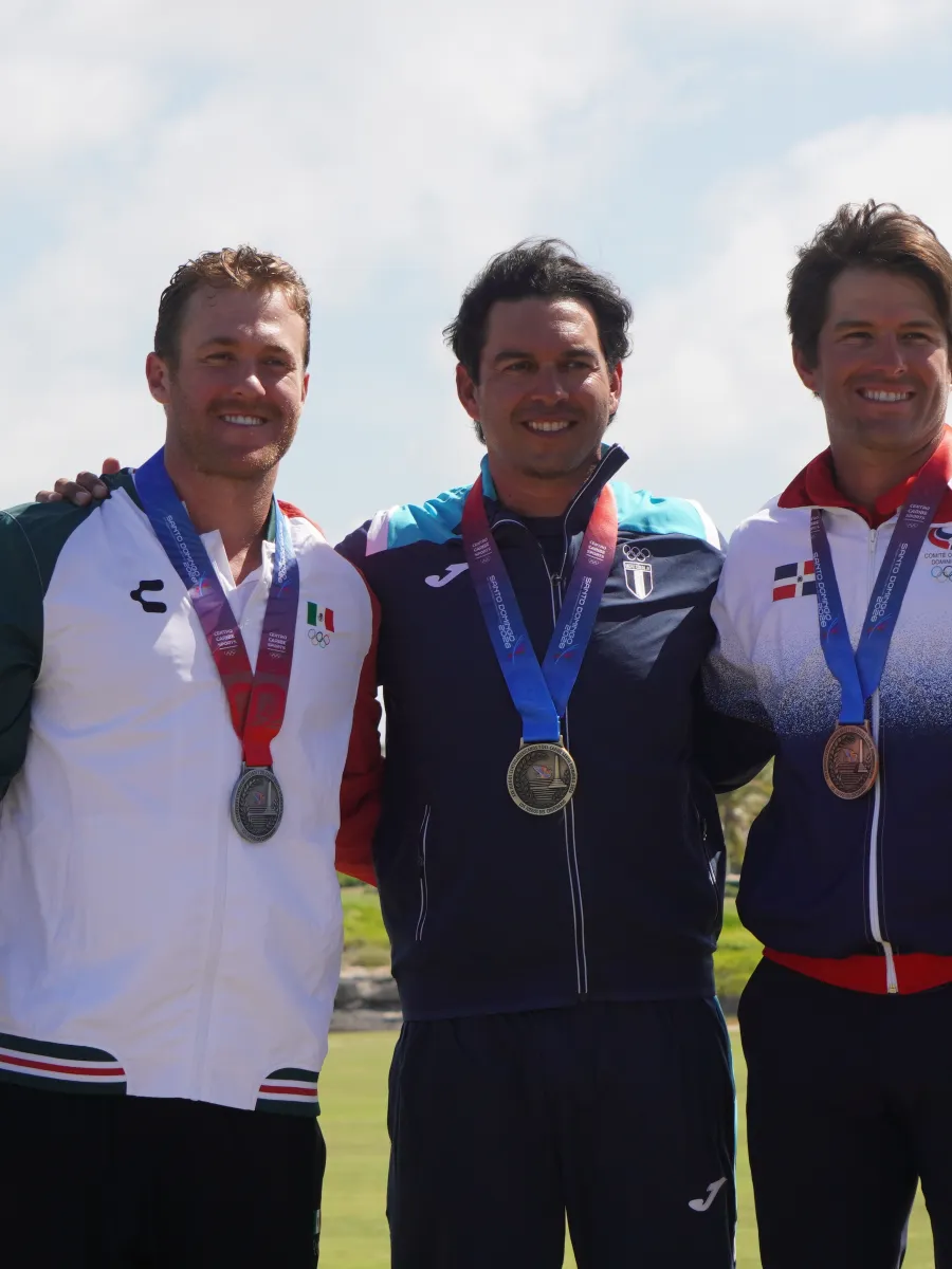 Tres golfistas medallistas posan juntos en un campo de golf